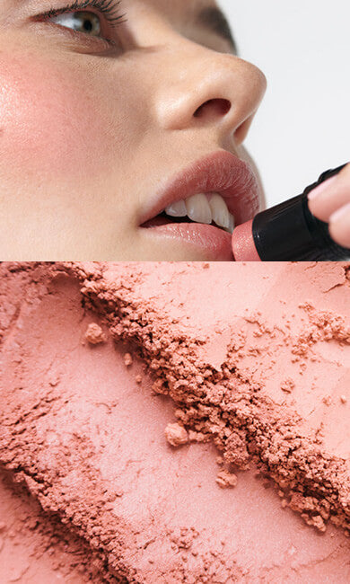 Person applying blush with a brush on a light background.