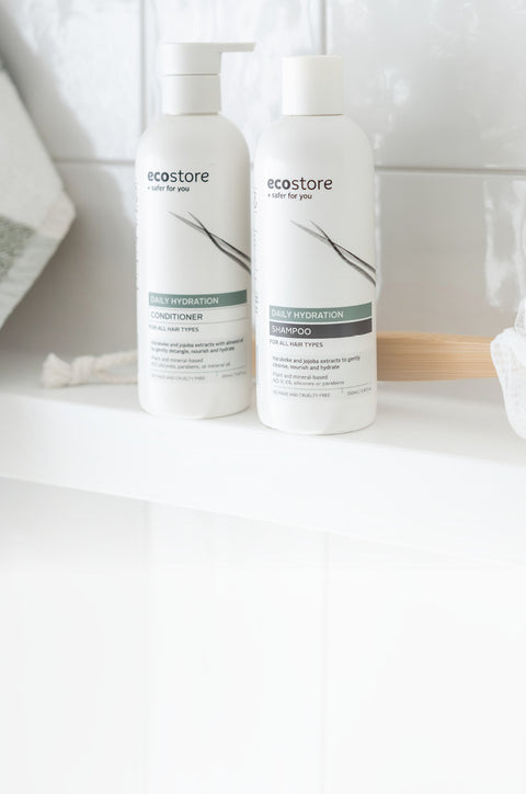 Two bottles of Ecostore hair care products on a bathroom counter.