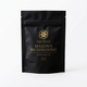 A black stand-up pouch labeled 'superfeast MASON'S MUSHROOMS immune de gut ricin' stands on a dark wooden surface. Surrounding props include mushrooms, ginger, cinnamon sticks, a spoonful of brown powder, and an old book, creating a rustic styled product scene.