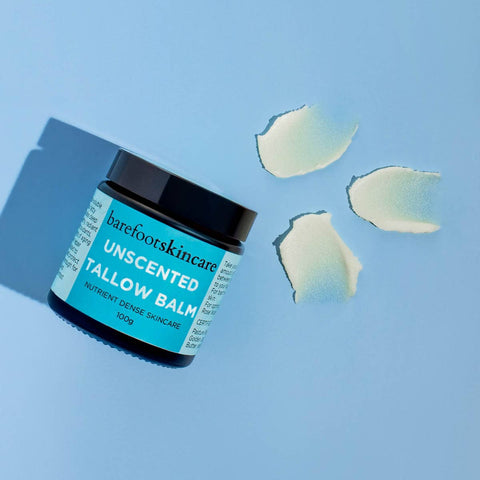 Unscented tallow balm on a blue background with multiple swatches next to it.