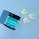 Unscented tallow balm on a blue background with multiple swatches next to it.