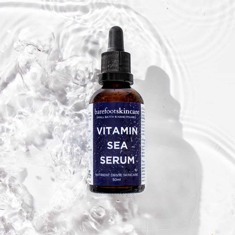 Bottle of Vitamin Sea Serum with a blue label on a textured white background