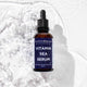 Bottle of Vitamin Sea Serum with a blue label on a textured white background