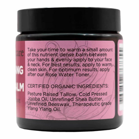 Back of tallow balm jar with pink label with usage instructions and ingredients on a white background