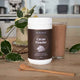 BioBalance Cacao Powder container with a glass of cacao drink on a wooden surface.