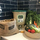 Bokashi One composting system with a bag and vegetables on a counter.