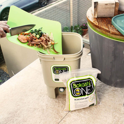 Person putting food scraps in Bokashi One composting system.