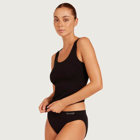 A woman modeling black activewear, featuring a sleeveless scoop-neck tank top and matching high-cut briefs with the brand name 'booster' printed on the waistband, set against a solid light gray background.