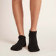 Black unisex ankle socks worn by a woman.