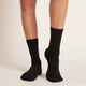 Woman wearing everyday crew socks in black.