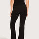 Black high-waisted flared leggings shown on a model from the back.