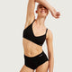 Boody Period & Leak Proof Full Briefs Light-Moderate Black lifestyle shot of a smiling woman with one arm raised in a black bra and the briefs