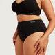 Boody Period & Leak Proof Full Briefs Light-Moderate lifestyle close up of a person's hand on the hip of the black full briefs, side view