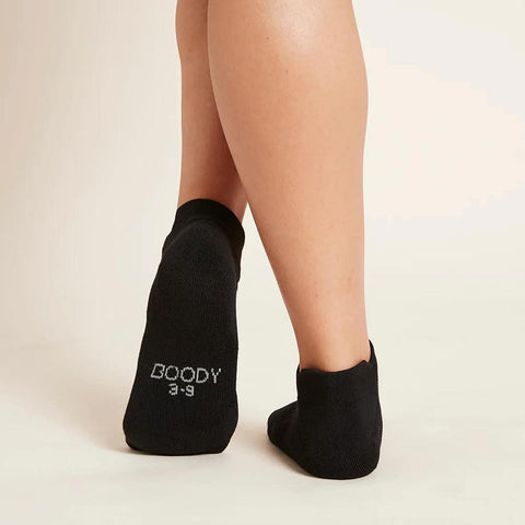 Black sport ankle socks worn by a woman with Boody branding on the bottom.