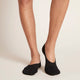 Black no-show socks worn by a model standing against a neutral background