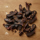 Dried beef jerky on a wooden surface with nutritional information displayed.