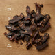 Dried beef jerky on a wooden surface with nutritional information displayed.
