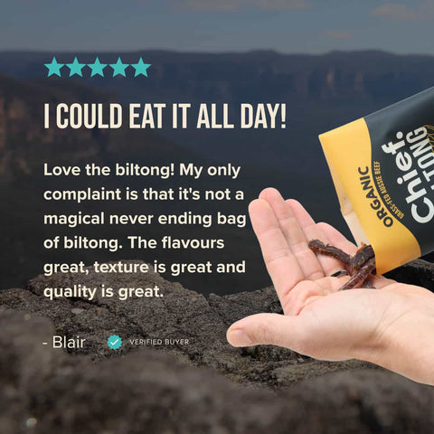 Chief Organic Biltong packaging with a hand holding biltong against a mountainous background with a 5 star review.