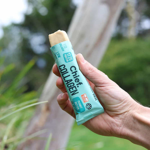 Hand holding a Chief Collagen supplement stick pack with a natural background
