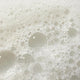 Close-up of white foam bubbles on a light gray background