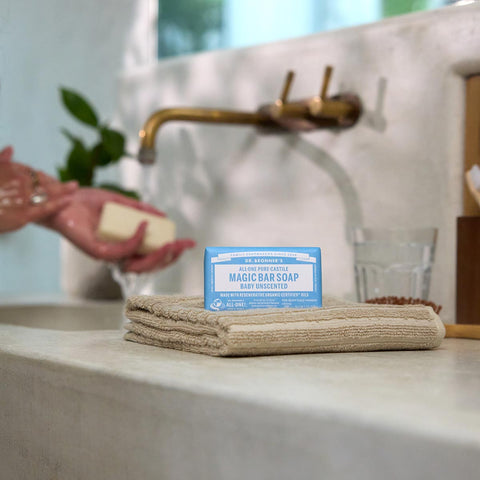 Bar of soap with a blue label on a towel next to a sink