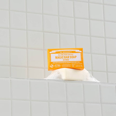 Bar of soap with a yellow label on a tiled bathroom shelf