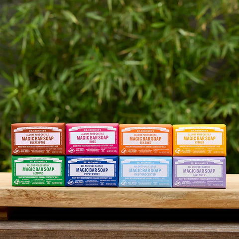 Assorted Magic Bar Soaps on a wooden surface with a green leafy background