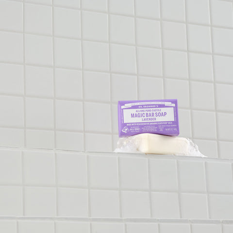 Lavender magic bar soap with a purple label on a tiled bathroom wall.