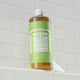 Bottle of Dr. Bronner's Magic Soap Green Tea on a tiled bathroom shelf