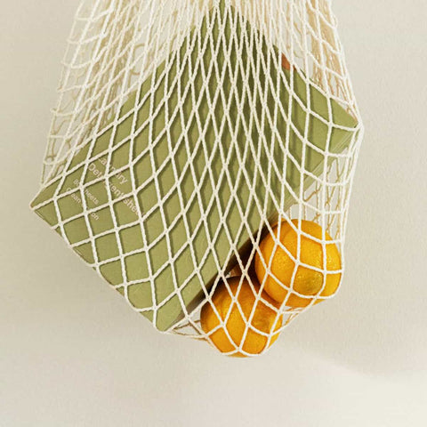 Net produce bag with box of laundry detergent sheets and lemons.