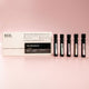 Set of 'ECO. Modern Essentials' mini perfume bottles with packaging on a pink background.