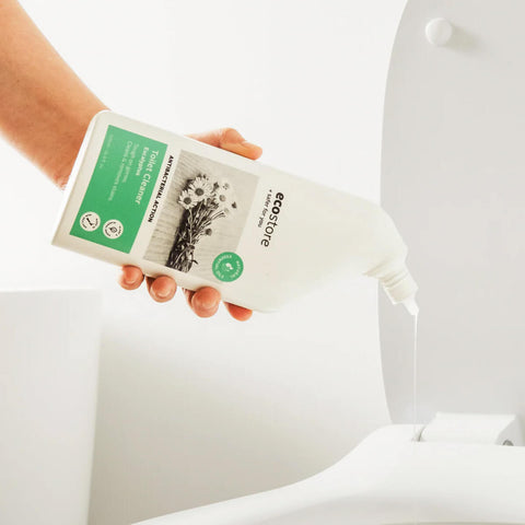 Person pouring toilet cleaner into a toilet bowl.