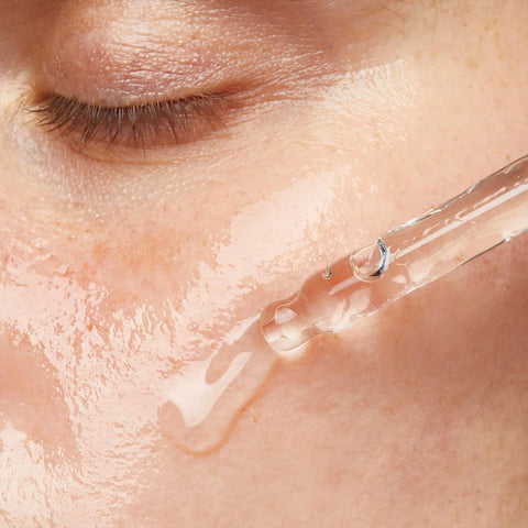 Close-up of a dropper applying Edible Beauty Super Stem Cell Concentrate clear liquid to skin.