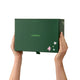 A person holds a dark green Endota product box against a plain white background. The box features the brand name 'endota' in light green, decorated with small pastel-coloured stars on the lower right corner.