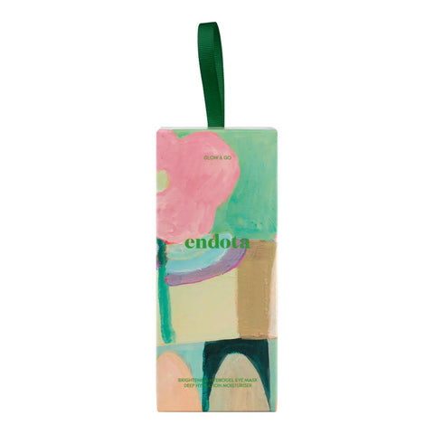 A rectangular skincare gift set with a hanging green ribbon, featuring an abstract floral painting in pink, green, beige, and purple. The brand name 'endota' is printed in green across the center.
