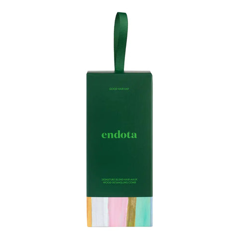 Endota Signature Blend Hair Care gift box in forest green with a matching green ribbon loop and pastel rainbow-coloured accents at the bottom, shown on a plain white background.