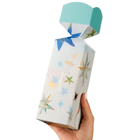 Hand holding a endota Hands & Feet Bon Bon with star pattern.