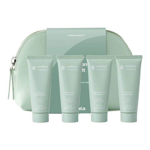 endota Organics skincare gift set featuring four tubes of facial products lined up in front of a matching mint green zippered pouch and box on a white background.