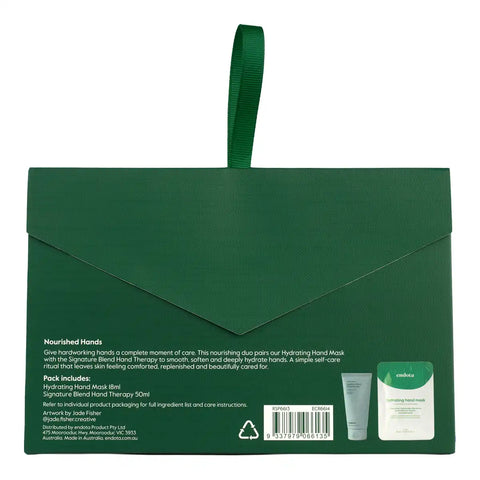 The back of a dark green Nourished Hands gift box, featuring a matching green ribbon handle, product description text, a barcode, and a small inset image of the hand mask packet.