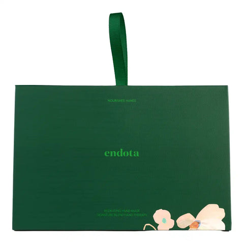 A dark green rectangular product box with a matching green ribbon handle, featuring the brand name 'endota' in light green text and a small floral illustration near the bottom right corner, set against a plain white background.