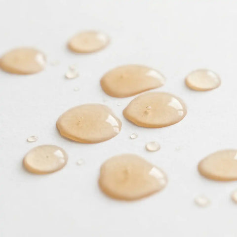 Light orange-coloured droplets on a white surface.