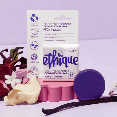 Ethique brightening purple conditioner bar with packaging and vanilla bean on a light purple background