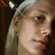 Close-up of a person applying a dropper of eye of horus regenerative night serum to their face.