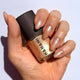 Hand holding a bottle of HANAMI holograms nail polish with a white background