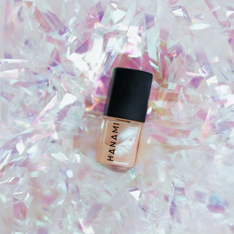 Holograms nail polish with black cap on a glittery, iridescent background