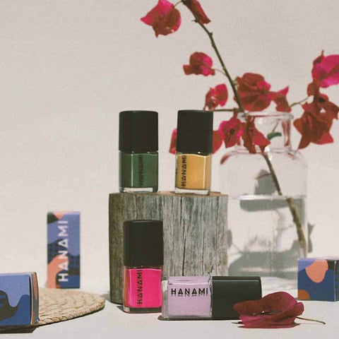 Collection of Hanami nail polish bottles and packaging on a neutral background with flowers.