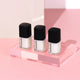 Three Hanami nail polish bottles on a pink platform with a light pink background