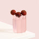 Stylish wavy glass of light pink protein water with lychees on a pink background.