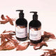 Two bottles of shampoo and conditioner with labels on a white background with brown leaves.