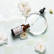 Skincare bottle with dropper and flowers on a white background.